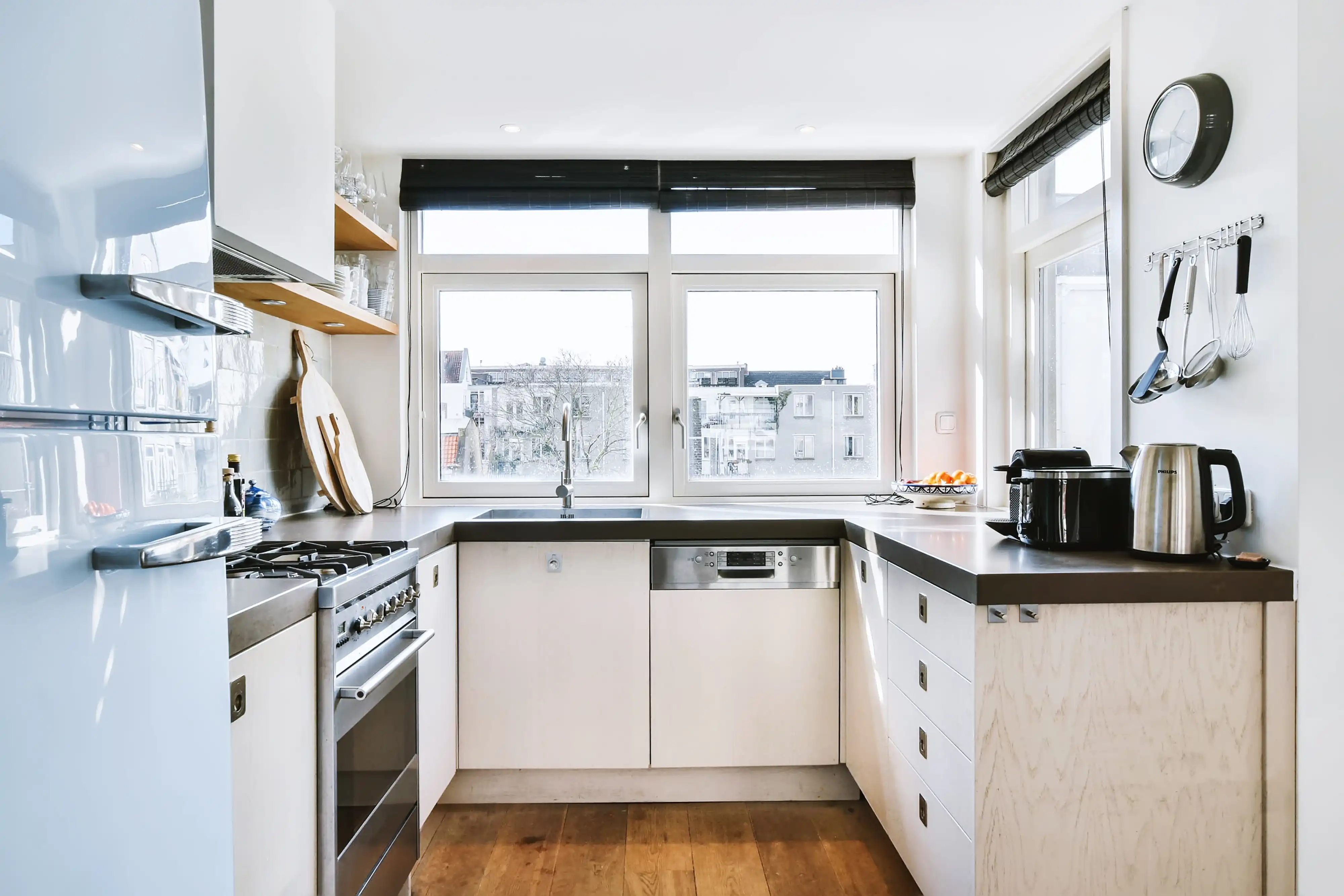 A compact kitchen with white cabinets, a small island, and natural light from a window above the sink
